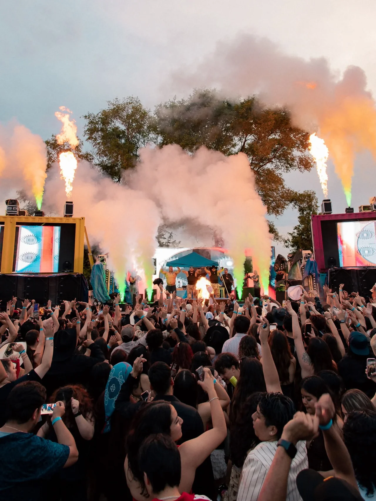 An outdoor concert crowd surrounded by live visual effects