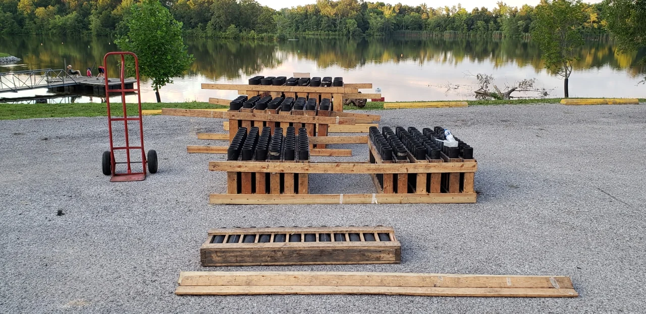 Prepared pyrotechnic racks at a lakeside outdoor display site